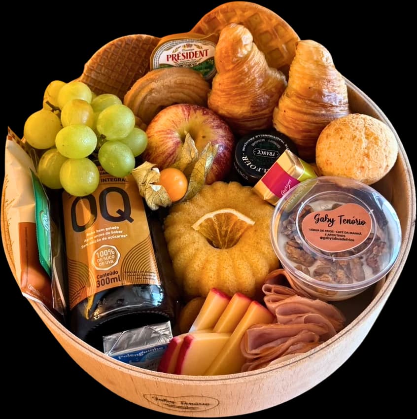 Box redonda de madeira com croissants, bolo, uvas, suco e frios
